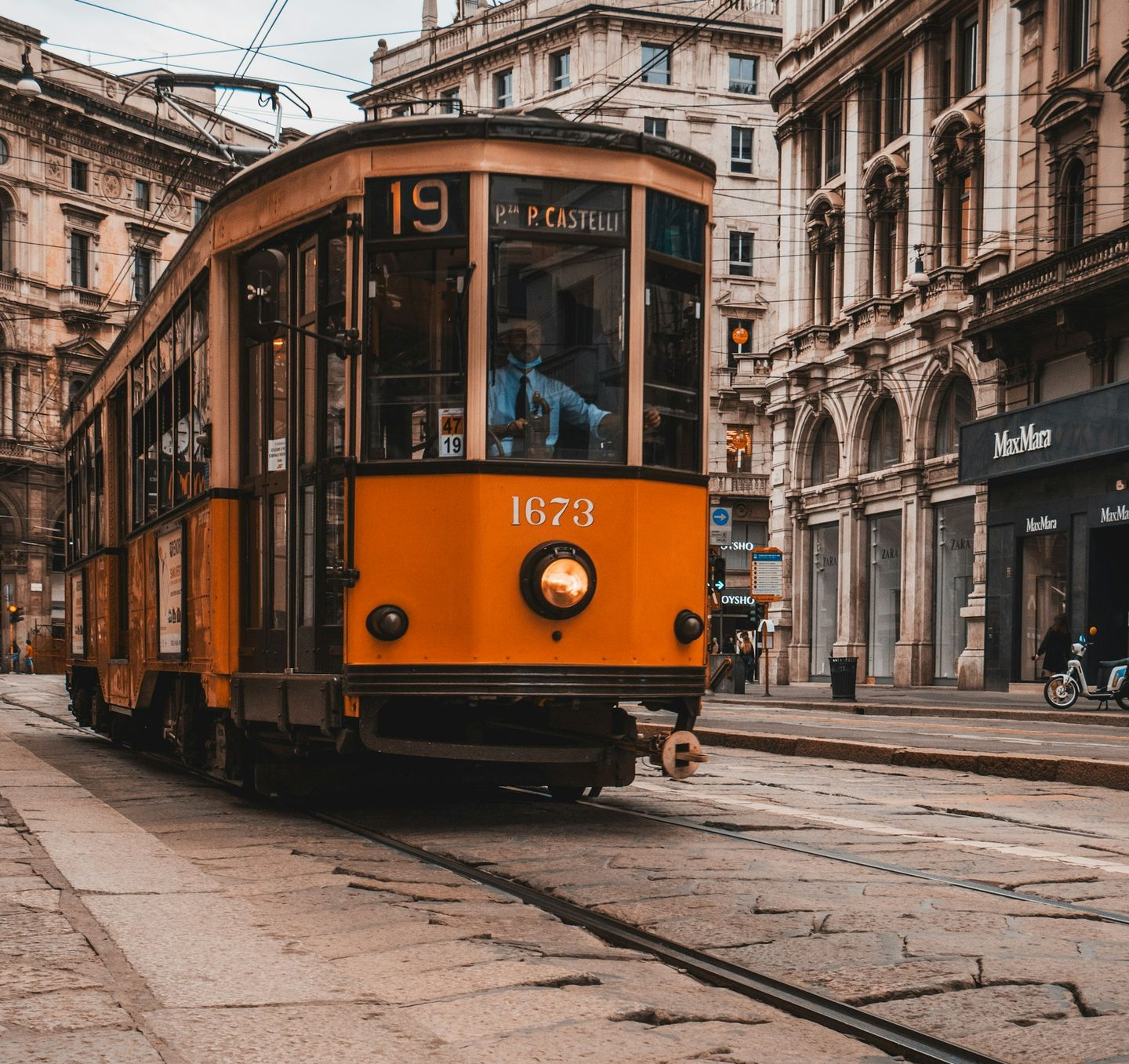 orange tram on road near building during daytime