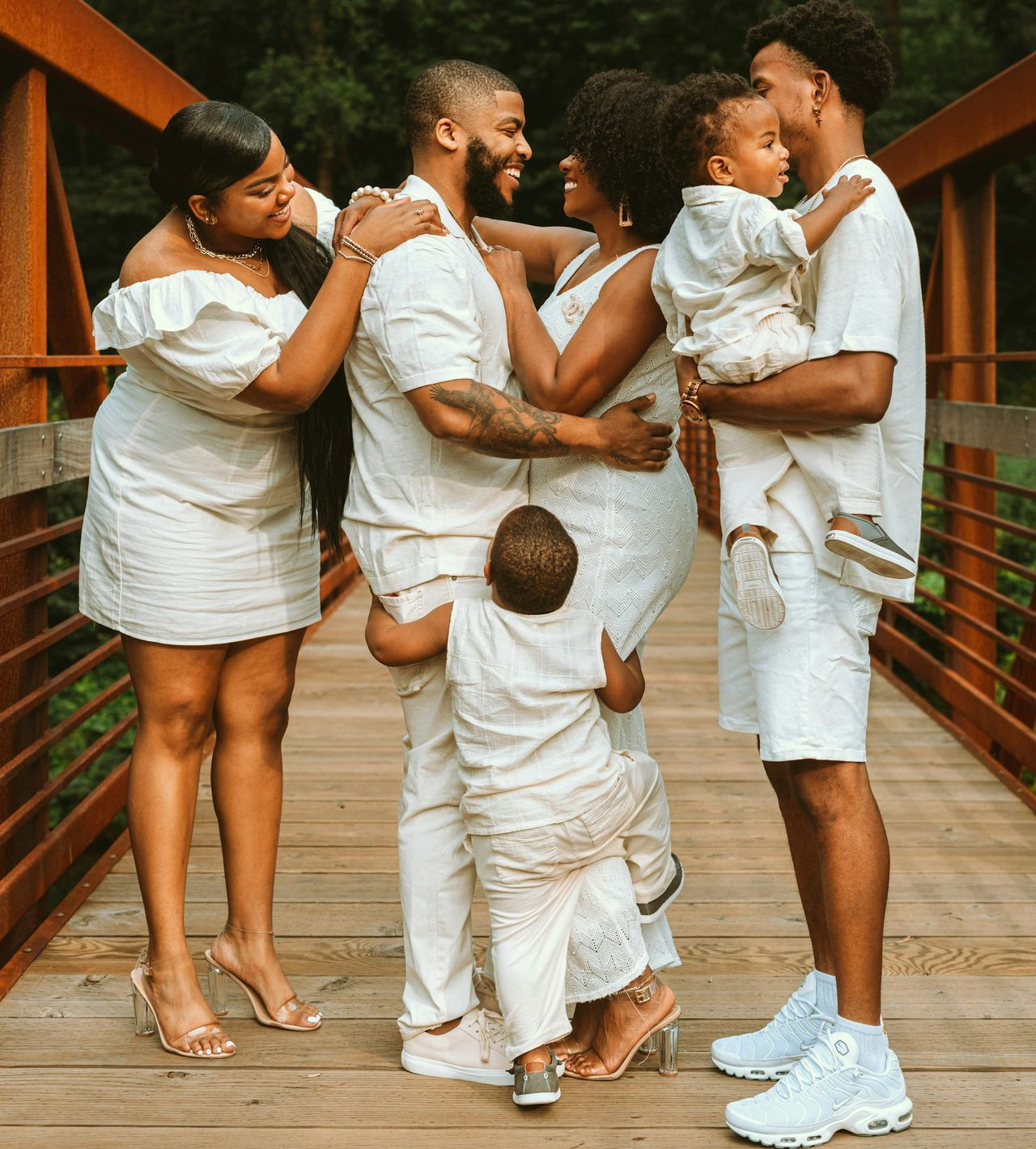 man in white dress shirt carrying baby in white dress